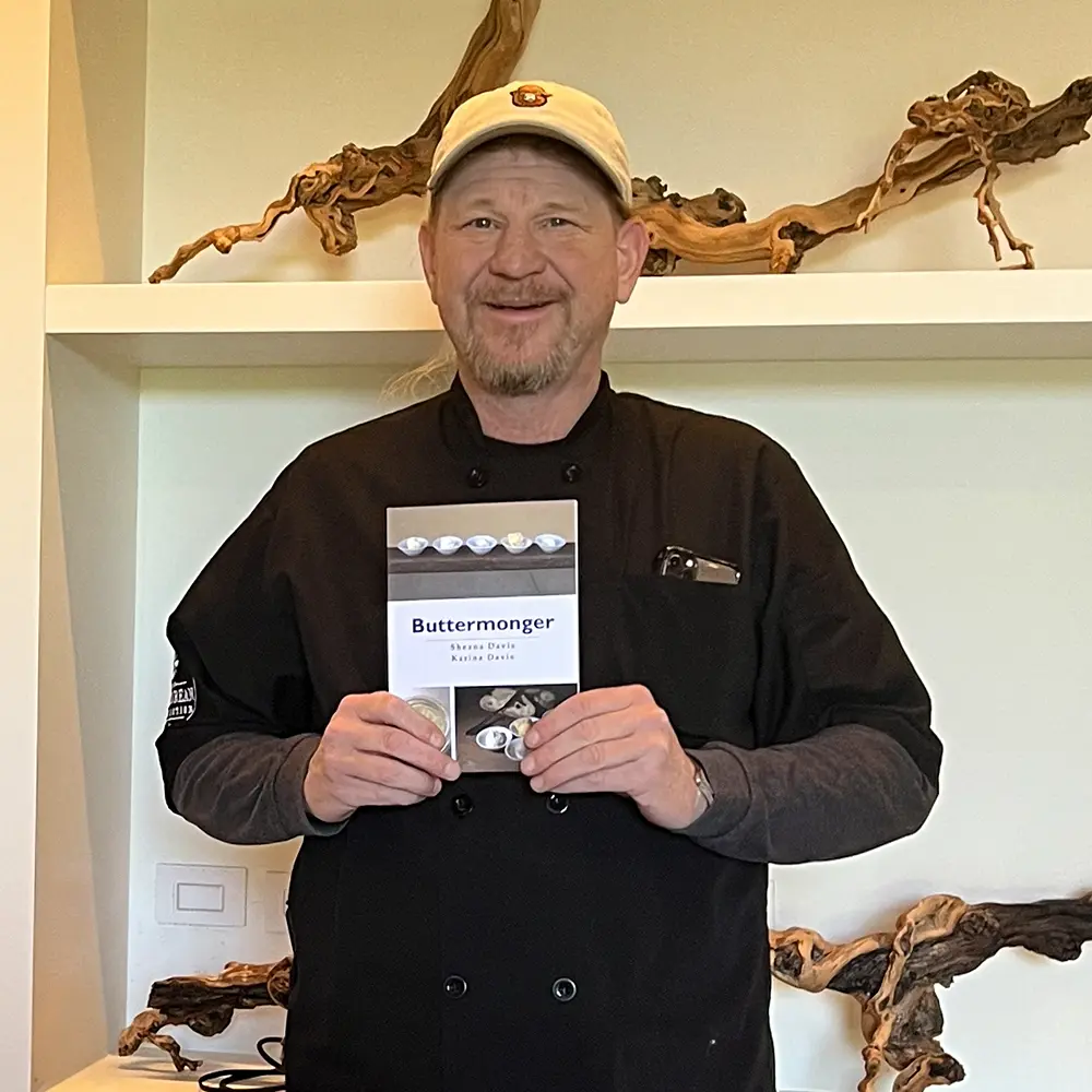 Ben Sessions holding Buttermonger book at an event