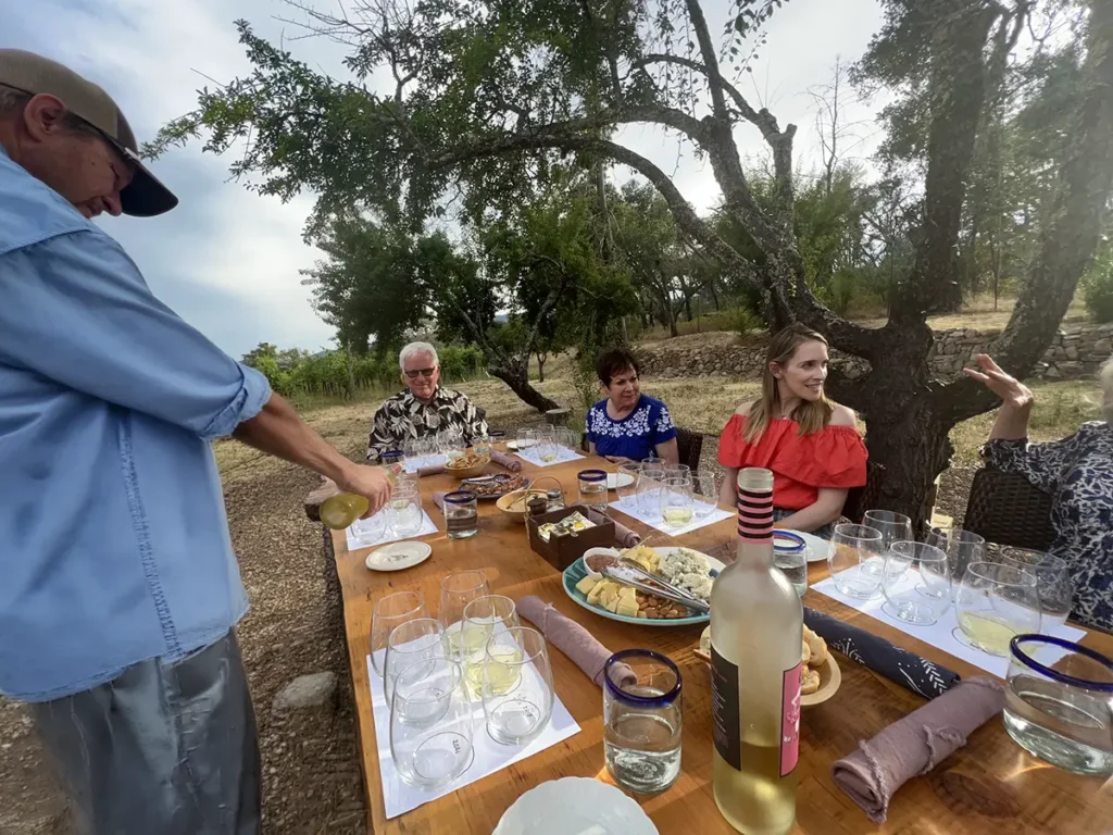 Ben Sessions pours wine at a private catering event for a small group