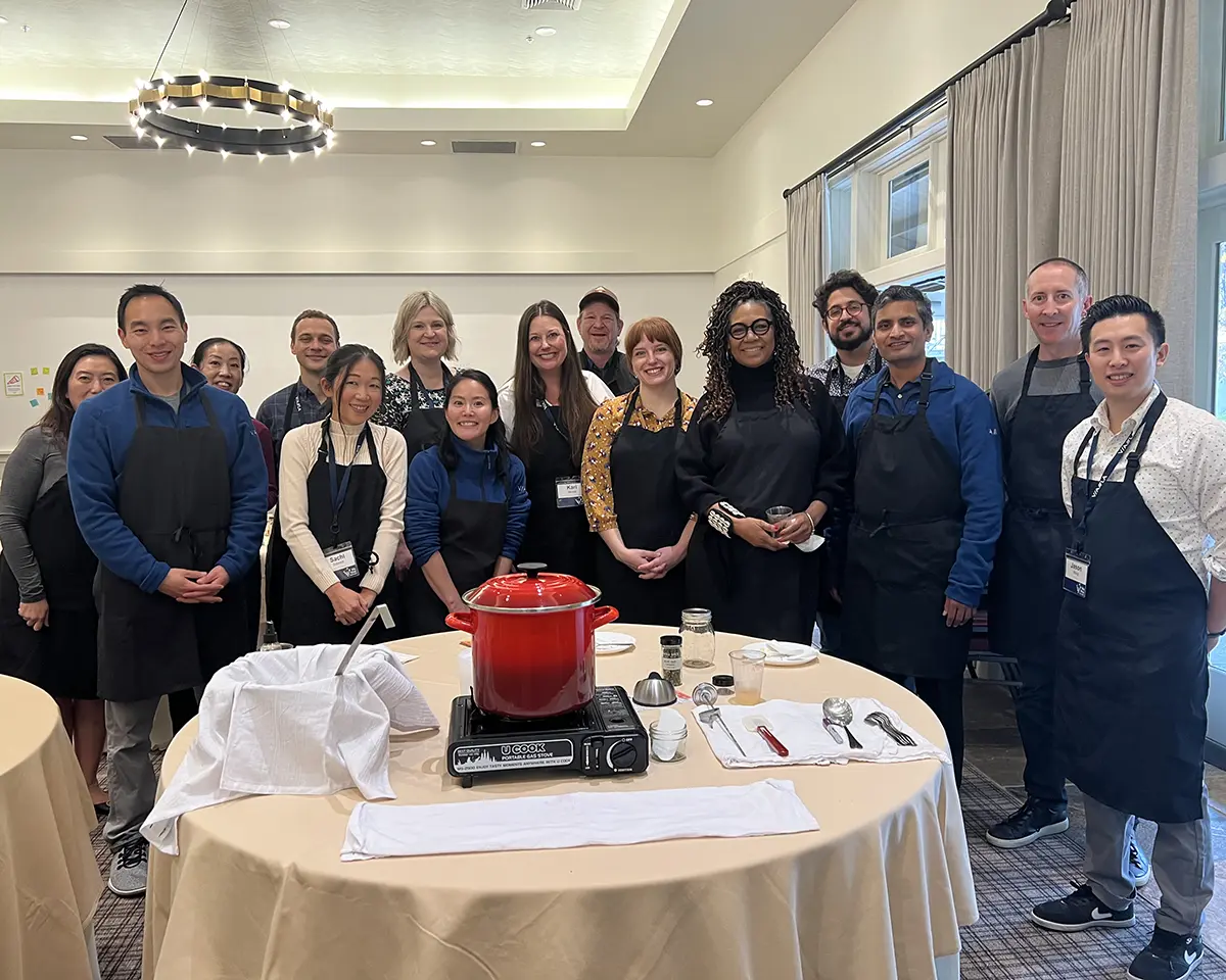A large group poses during a corporate cheesemaking class