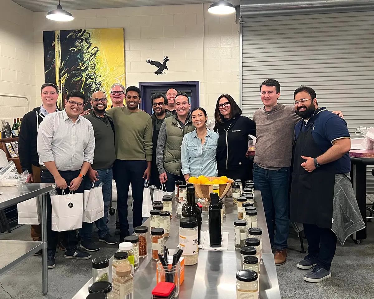 A group of colleagues celebrate after taking a cheesemaking class