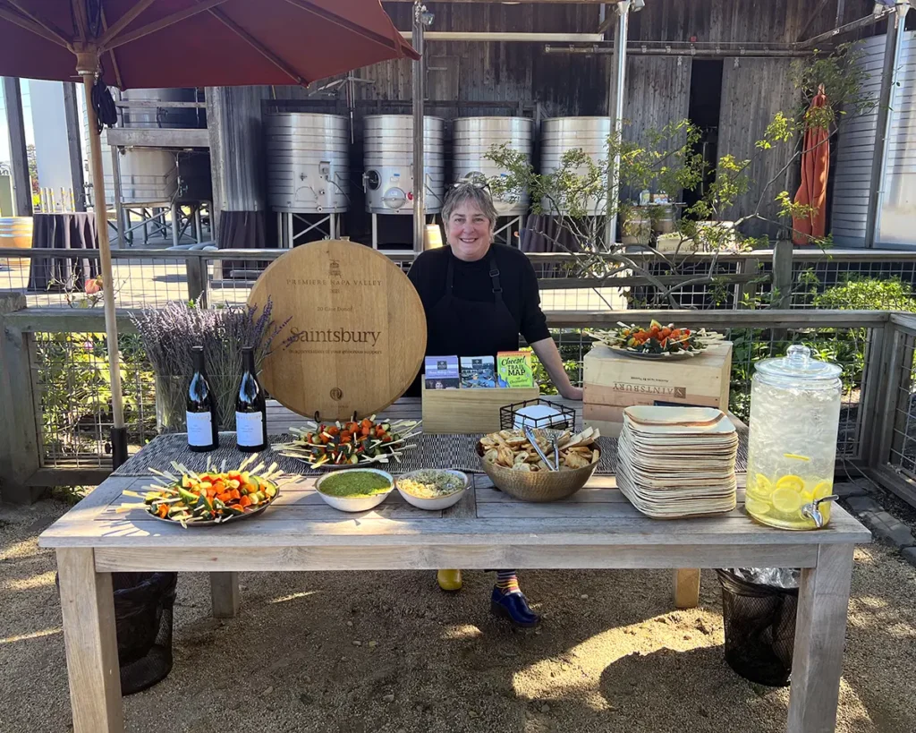 Sheana Davis stands at a welcome table for a catering event at Saintsbury Winery in Napa, California